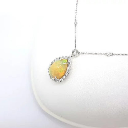 Opal and Diamond Pear Cluster Pendant Necklace; 10.00 carat pear-shaped cabochon-cut opal surrounded by 1.80cts diamonds, on a diamond set chain, in 18ct white gold