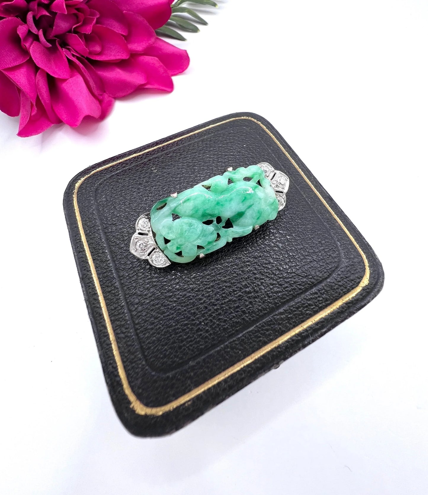 A carved green jade and diamond brooch in white gold