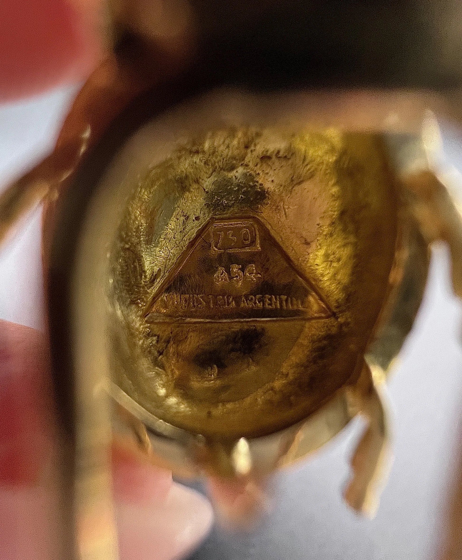 Close-up of stamps on a yellow gold brooch
