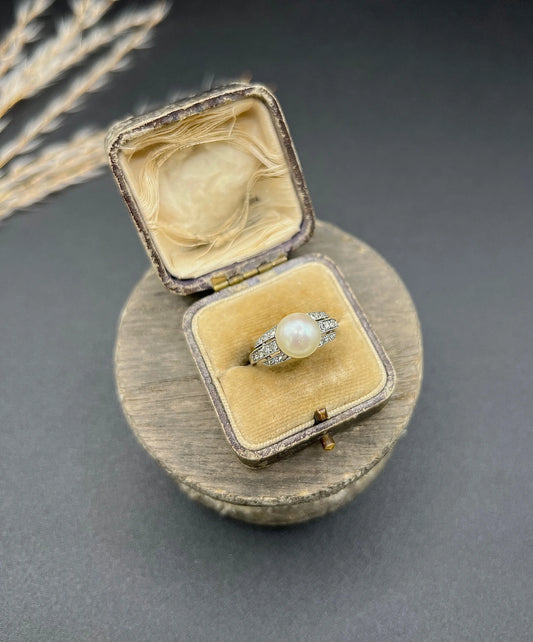 A pearl and diamond ring in platinum, in an antique ring box