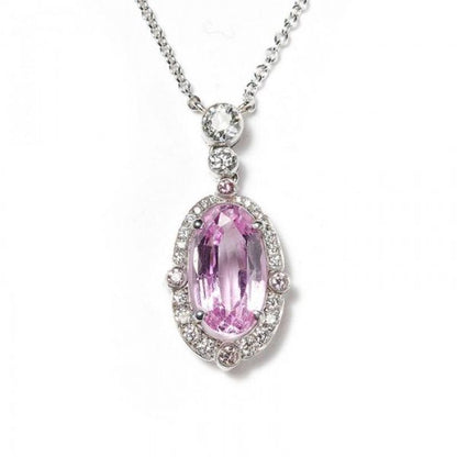 2.84ct Pink Topaz and Diamond Oval Cluster Pendant; set with a 2.84ct oval faceted pink topaz surrounded by a diamond halo, accented with pink diamonds on the quarters, and round brilliant-cut diamonds on the bale. Mounted in platinum and presented on a platinum trace chain.