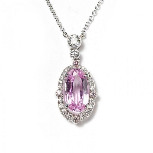 2.84ct Pink Topaz and Diamond Oval Cluster Pendant; set with a 2.84ct oval faceted pink topaz surrounded by a diamond halo, accented with pink diamonds on the quarters, and round brilliant-cut diamonds on the bale. Mounted in platinum and presented on a platinum trace chain.