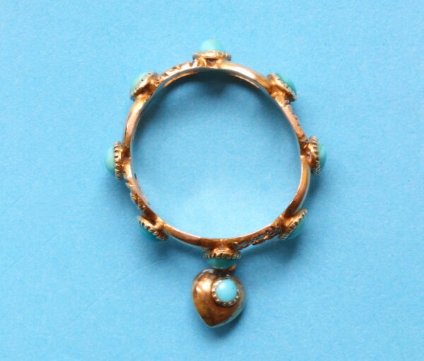 Antique Georgian Turquoise and Gold Ring; set with round cabochon cut turquoises from which suspends a small heart shaped locket. England, Circa 1840