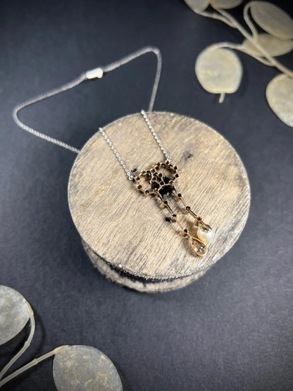 An antique diamond and pearl double drop pendant necklace, on a wooden spool