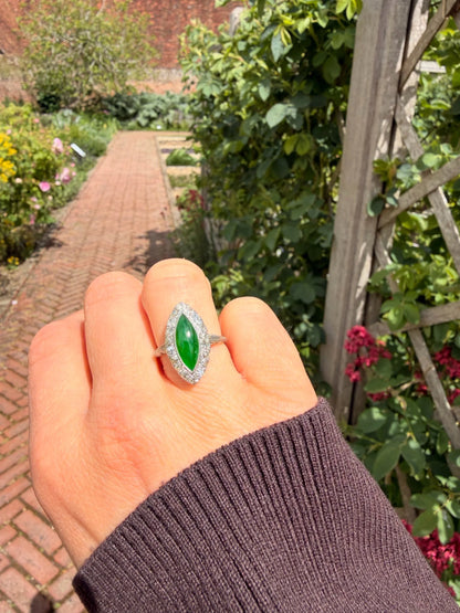 A jade and diamond navette shaped cluster ring in platinum, modelled on a hand
