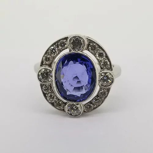 Sapphire and Diamond Oval Cluster Dress Ring; central 3.30 carat oval faceted sapphire surrounded by a 0.90ct diamond set halo, comprising of four larger diamonds interspersed with three smaller diamonds. Mounted in platinum