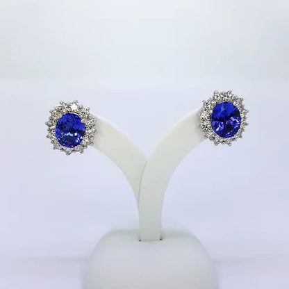 Tanzanite and Diamond Oval Cluster Earrings; 5.20cts oval faceted tanzanites surrounded by 1.76cts round brilliant-cut diamonds, in 18ct white gold