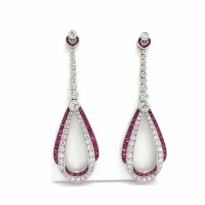 Ruby, Diamond and Platinum Drop Earrings; featuring rows of brilliant-cut diamonds and calibre cut rubies intertwined in a double loop, suspended from a graduated diamond set drop