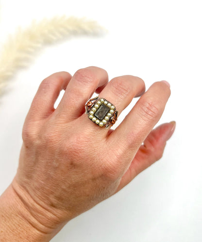 An antique seed pearl mourning ring in gold, modelled on a hand
