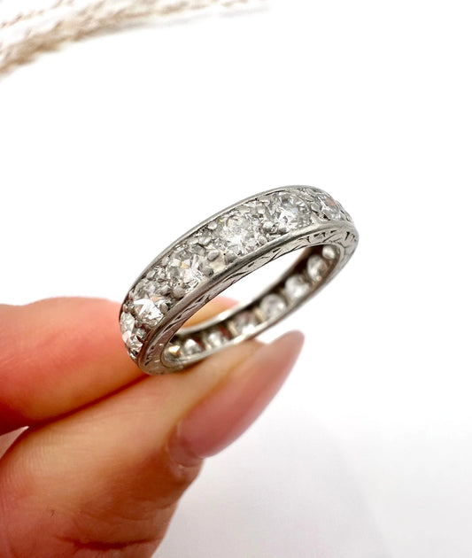 A diamond full eternity band ring in platinum, held in a hand