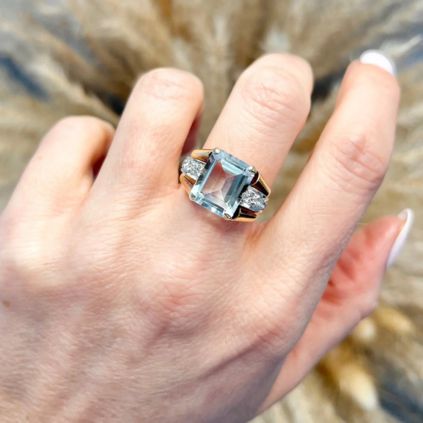 An aquamarine and diamond cocktail ring in gold, modelled on a hand
