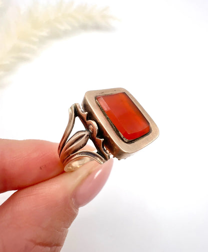 An antique carnelian mourning ring in gold, held in a hand