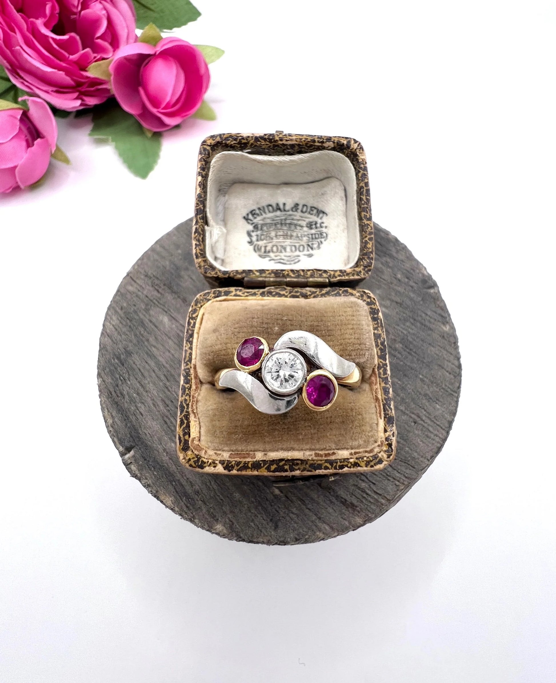A three stone ruby and diamond crossover ring in platinum and yellow gold, in a ring box