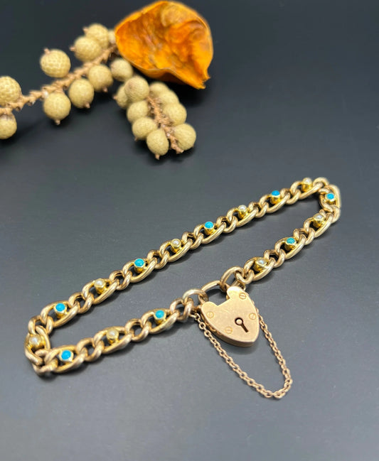 A yellow gold curb link bracelet with turquoise, pearls and a heart-shaped padlock