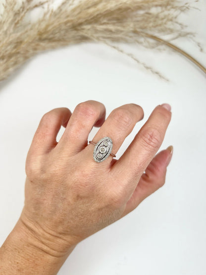 Antique 18 Carat White Gold Three Stone Diamond Oval Halo Ring, Circa 1910