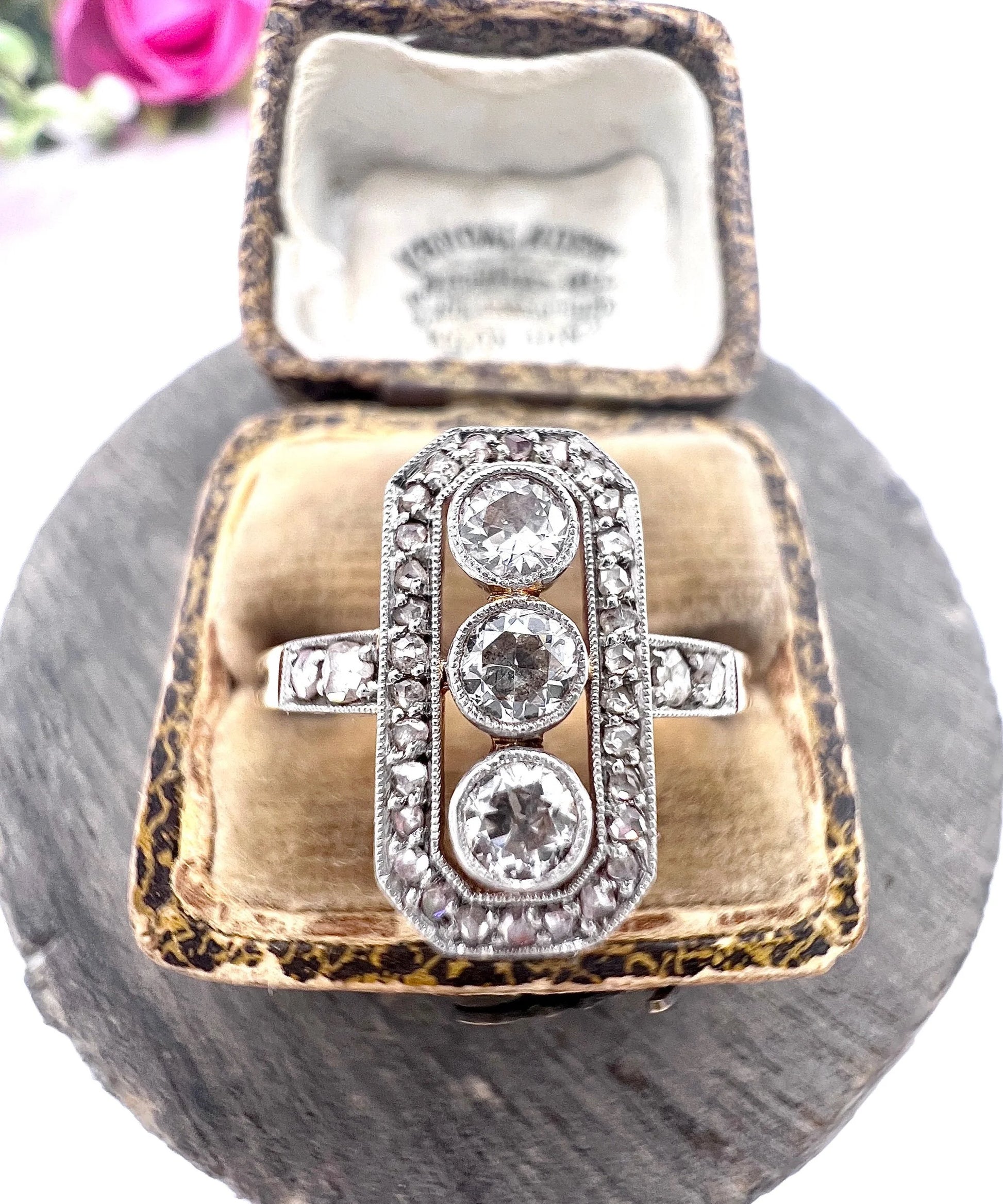 A diamond open cluster ring with three principal diamonds, in yellow and white gold, in a ring box