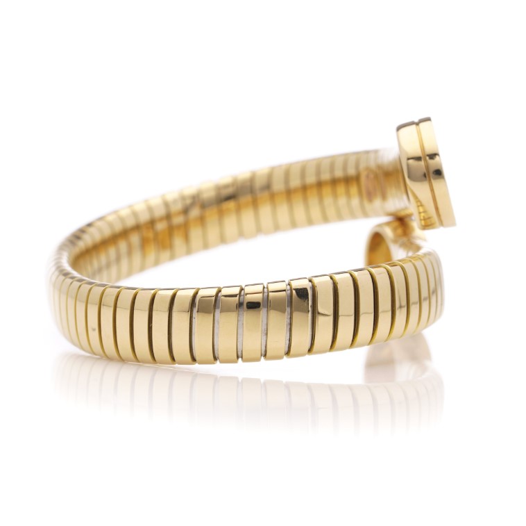 Vintage Bvlgari 18ct Yellow Gold and Onyx Tubogas Bangle Bracelet, 18ct yellow gold tubogas flexible sprung cuff made of coiled gas pipe links with terminals of circular onyx plaques encased in a polished surround engraved with the BVLGARI BVLGARI motif. Made in Italy, Alexandria, Circa 1990s