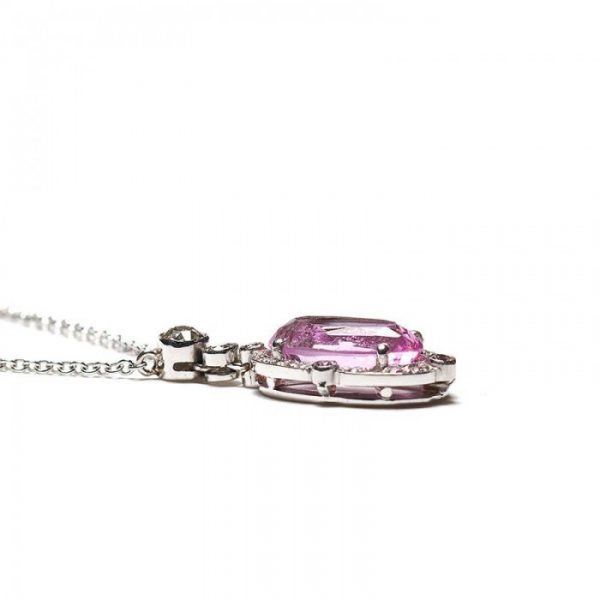 2.84ct Pink Topaz and Diamond Oval Cluster Pendant; set with a 2.84ct oval faceted pink topaz surrounded by a diamond halo, accented with pink diamonds on the quarters, and round brilliant-cut diamonds on the bale. Mounted in platinum and presented on a platinum trace chain.