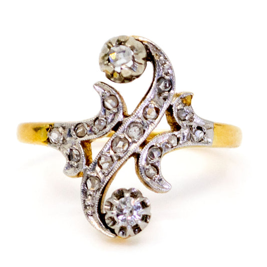 A yellow gold and platinum diamond fancy scroll design ring