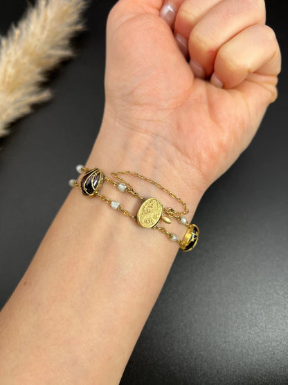 A yellow gold bracelet with oval cabochon garnets and white pearls, modelled on a wrist