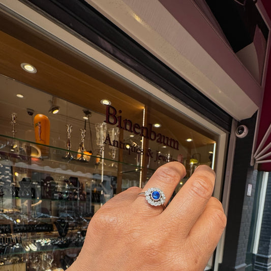 A sapphire and diamond flower shaped cluster ring in platinum, modelled on a hand