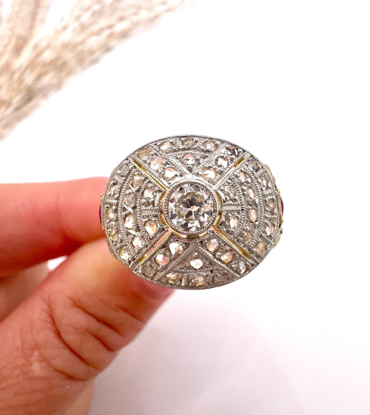 A diamond oval shaped bombé design ring, held in a hand