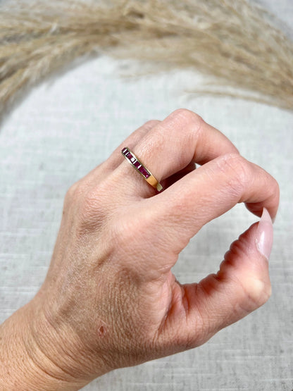 A yellow gold ruby channel set eternity band, modelled on a hand