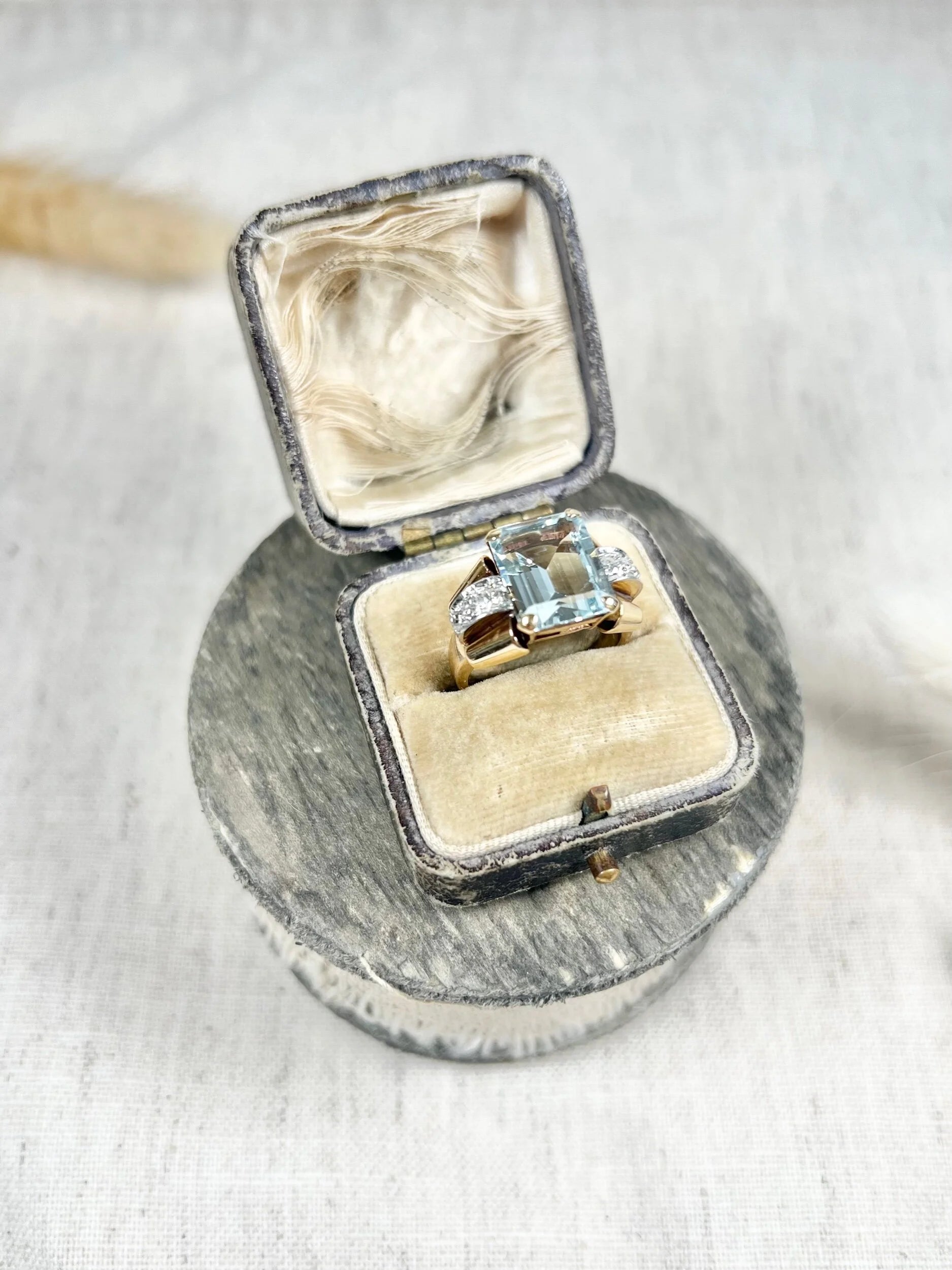 An aquamarine and diamond cocktail ring in gold, in an antique ring box