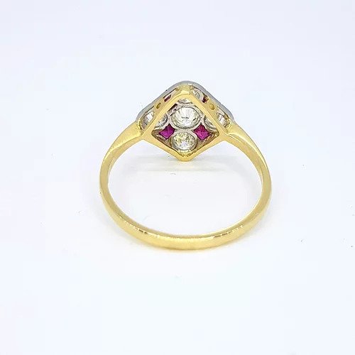 Ruby and Diamond Checkerboard Cluster Ring; five circular diamonds and four square faceted rubies arranged in a diamond-shaped checkerboard design, mounted in platinum to an 18ct yellow gold shank