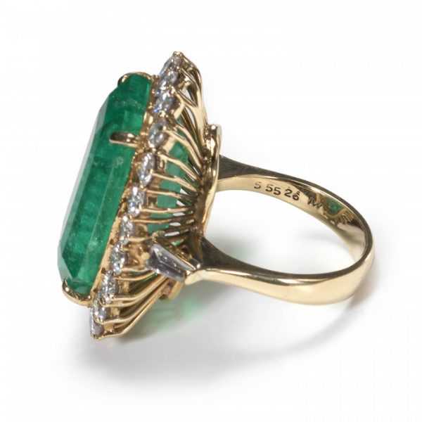 Vintage Colombian Emerald and Diamond Cluster Ring; 21.00 carat emerald-cut emerald surrounded by 2.20 carats of round brilliant-cut diamonds, in 18ct yellow gold, Circa 1980, with a GCS certificate