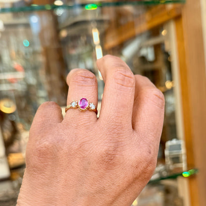 A three stone oval ruby and rose cut diamond ring in yellow gold, modelled on a hand