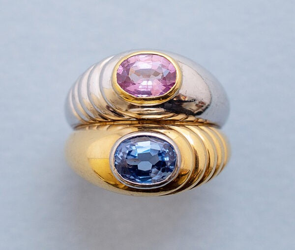 Vintage Italian 18ct Gold Double Ring with Pink and Blue Sapphire; white gold ring with 1.10ct oval pink sapphire in a yellow gold bezel, and 18ct yellow gold ring set with 1.10ct oval blue sapphire in a white gold bezel, Circa 1985