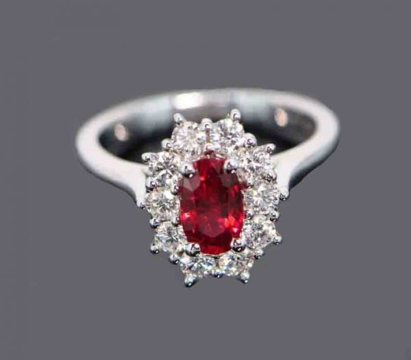 Burmese Ruby and Diamond Cluster Ring; 1.01ct oval faceted Burma ruby surrounded by 0.65cts diamonds, 18ct white gold. No indication of heat treatment