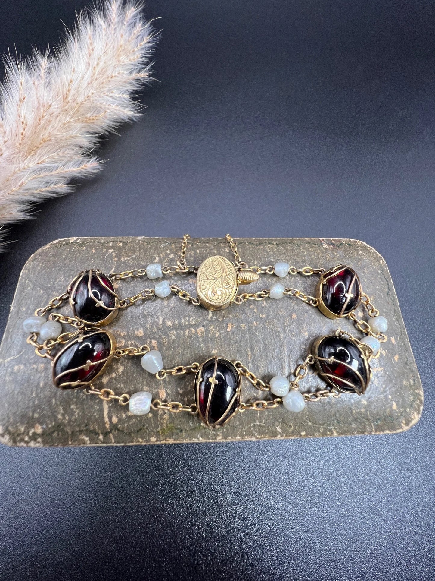 A yellow gold bracelet with oval cabochon garnets and white pearls