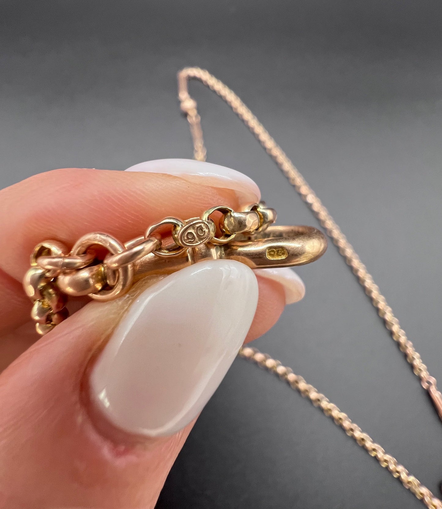 A long rose gold chain necklace with a dog clip clasp, with a 9C stamp