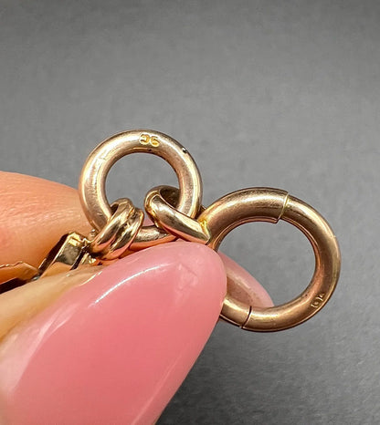 Close-up of a 9C stamp on a rose gold bracelet end ring