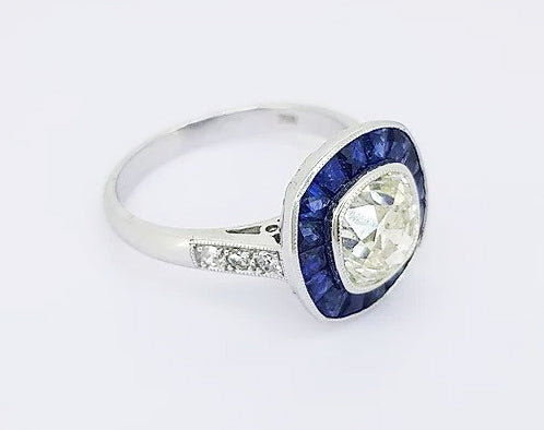 1.96ct Diamond and Sapphire Target Cluster Ring; central diamond surrounded by calibre-cut sapphires, collet-set, diamond set shoulders, 18ct white gold.