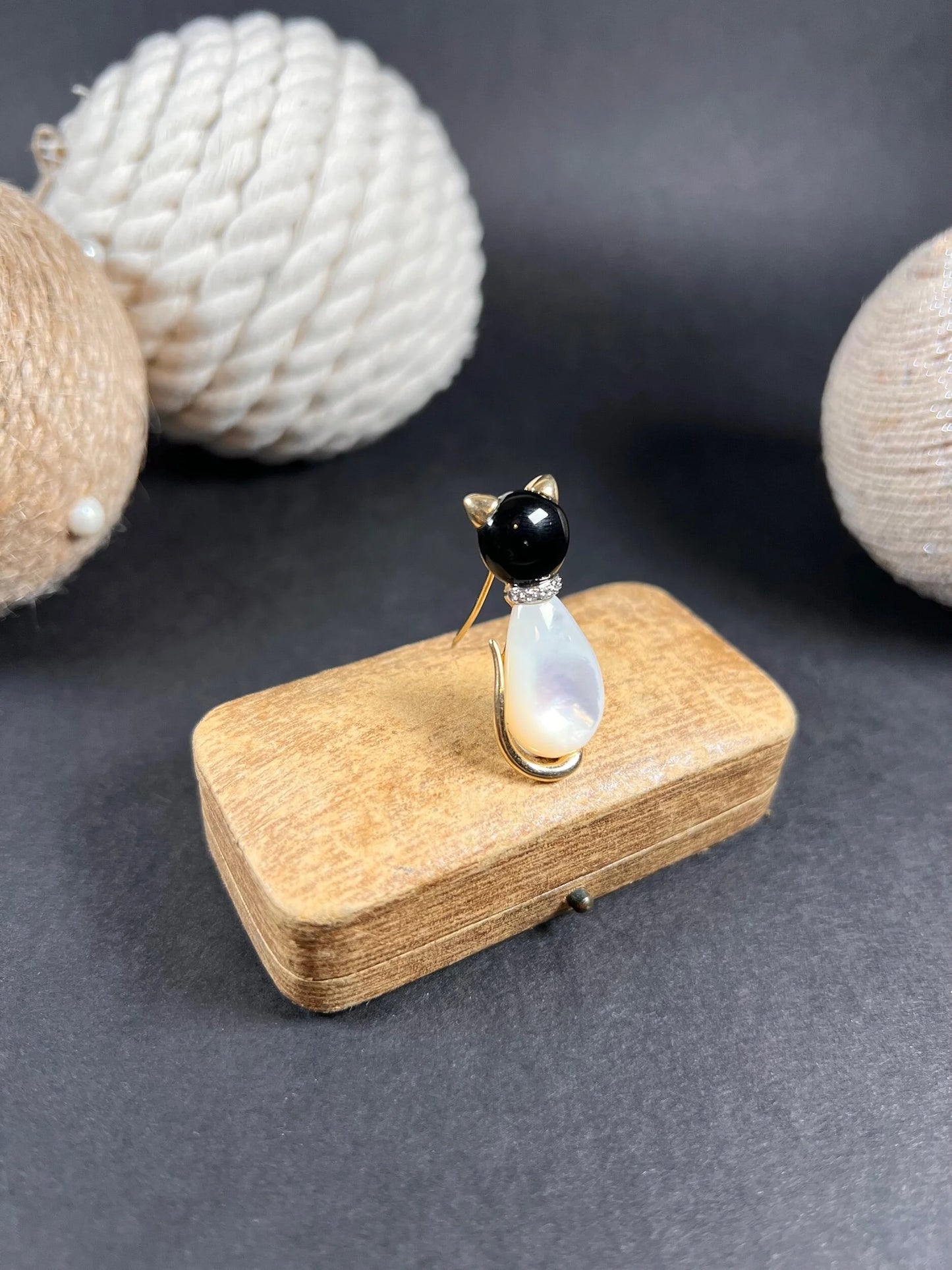 A cat-shaped brooch in yellow gold with black onyx, mother of pearl and a diamond set collar