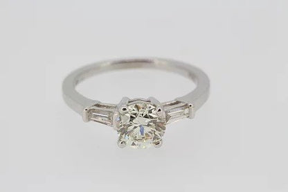 Diamond Solitaire Engagement Ring; central 1.22 carat round brilliant cut diamond with 0.24cts baguette cut diamonds to the shoulders, in 18ct white gold