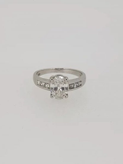 Oval Cut Diamond Engagement Ring with Princess Cut Shoulders; central 1.22 carat oval-cut diamond in a four-claw setting, with 0.36cts princess-cut diamond set shoulders, in 18ct white gold