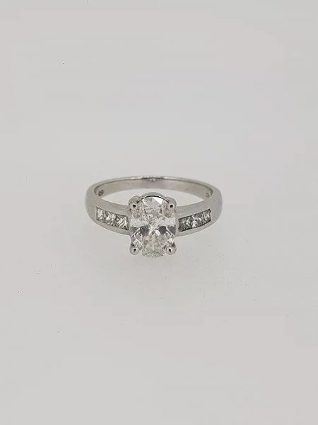 Oval Cut Diamond Engagement Ring with Princess Cut Shoulders; central 1.22 carat oval-cut diamond in a four-claw setting, with 0.36cts princess-cut diamond set shoulders, in 18ct white gold