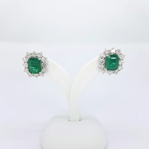 Emerald Cut Emerald and Diamond Cluster Stud Earrings; 4.25cts emerald-cut emeralds surrounded by 2.30cts round brilliant-cut diamonds, in 18ct white gold