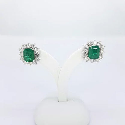 Emerald Cut Emerald and Diamond Cluster Stud Earrings; 4.25cts emerald-cut emeralds surrounded by 2.30cts round brilliant-cut diamonds, in 18ct white gold