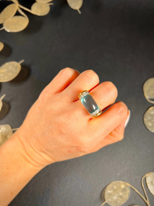 A blue topaz and diamond ring in yellow gold, modelled on a hand