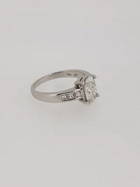 Oval Cut Diamond Engagement Ring with Princess Cut Shoulders; central 1.22 carat oval-cut diamond in a four-claw setting, with 0.36cts princess-cut diamond set shoulders, in 18ct white gold