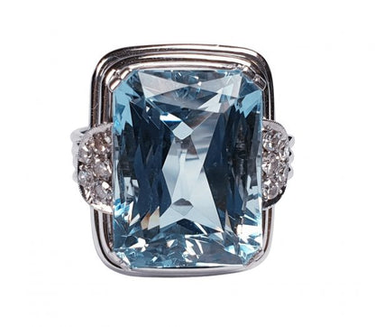 Art Deco Aquamarine and Diamond Dress Ring; a striking 14.80 carat emerald-cut aquamarine accented with half moon diamond cluster shoulders, on a three wire platinum band. Circa 1930s