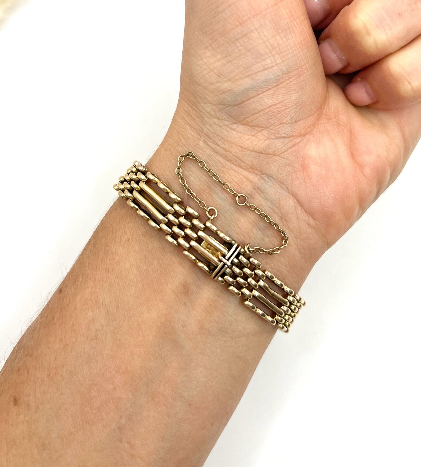 A yellow gold gate bracelet, modelled on a wrist