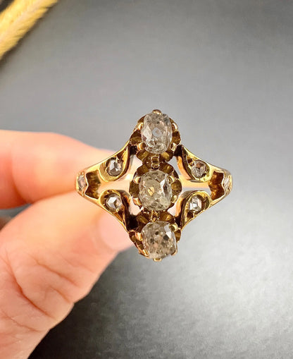 An antique old cut diamond ring in yellow gold, held in a hand