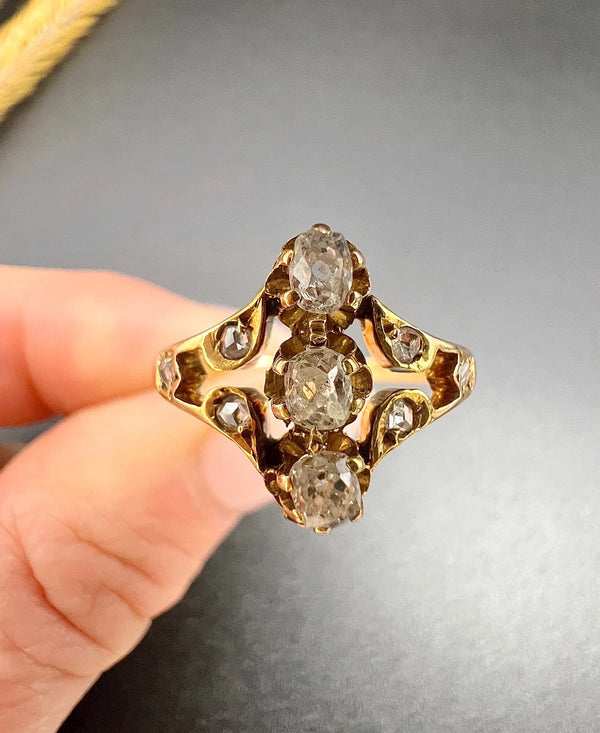 An antique old cut diamond ring in yellow gold, held in a hand
