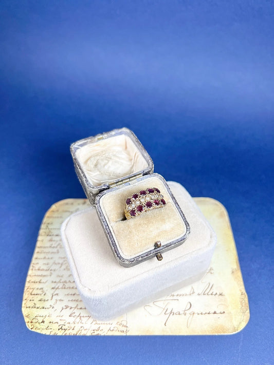 A yellow gold triple row ring with garnets and seed pearls, in a box